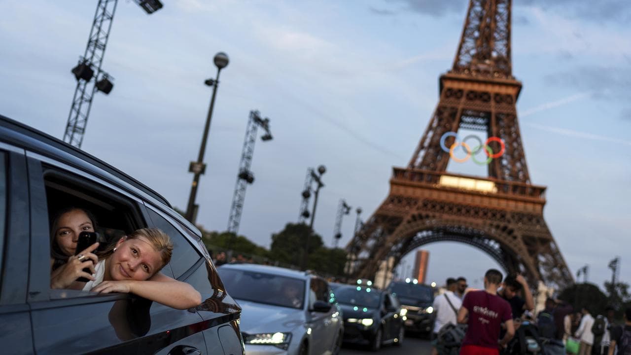 Passengers in a taxi film themselves as they leave the Eiffel Tower