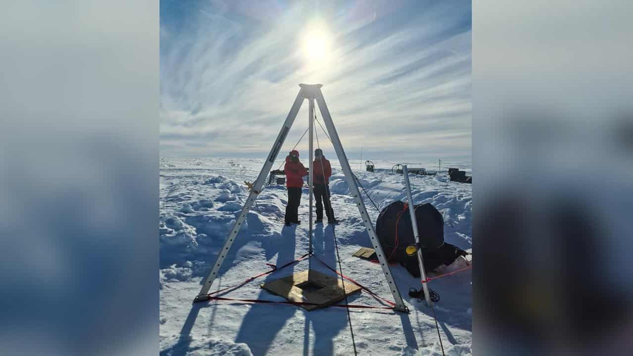 Researchers drill a borehole to test an ice shelf in Antarctica.