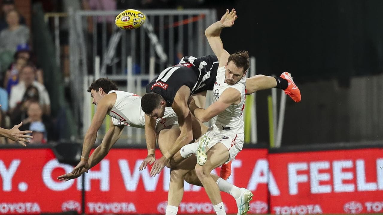 Three players clash in a contest for the ball.