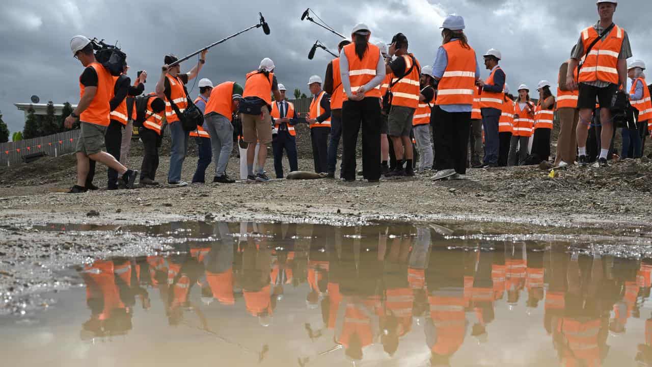 Peter Dutton talks to journalists at a housing construction site.