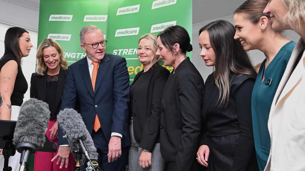 Prime Minister Anthony Albanese poses with clinicians for a photo