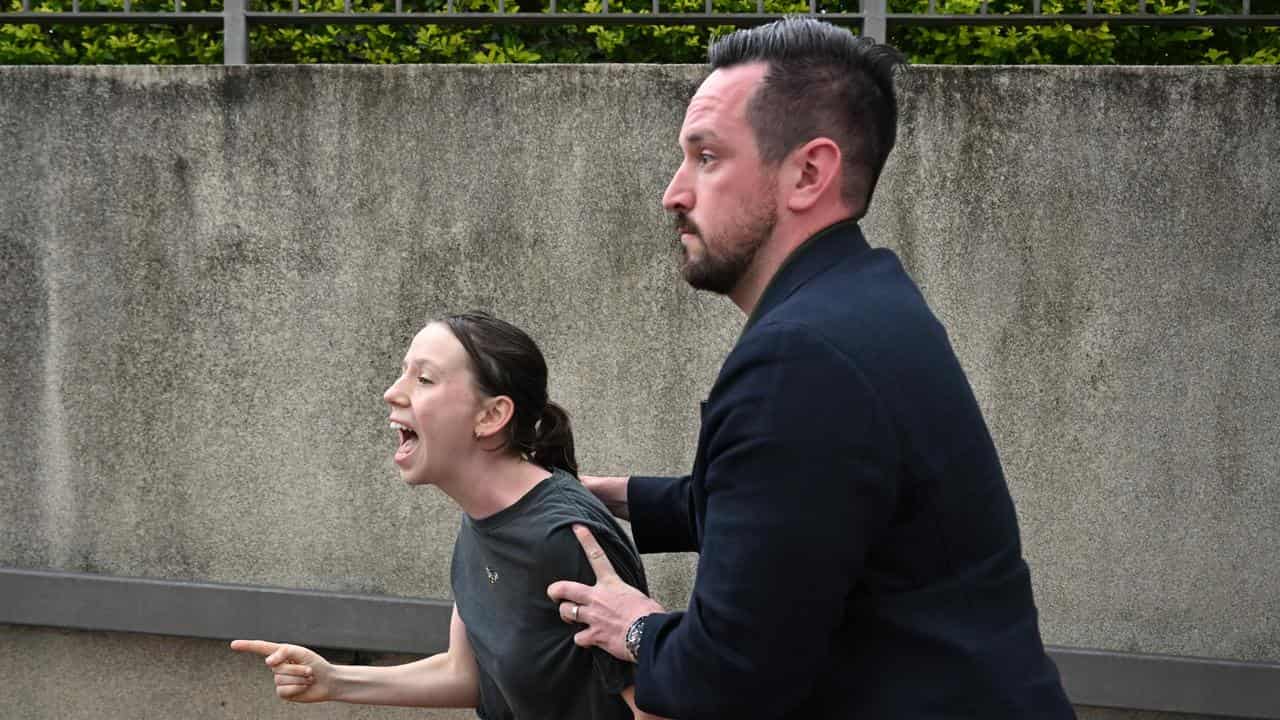A protester is escorted away after interrupting Anthony Albanese