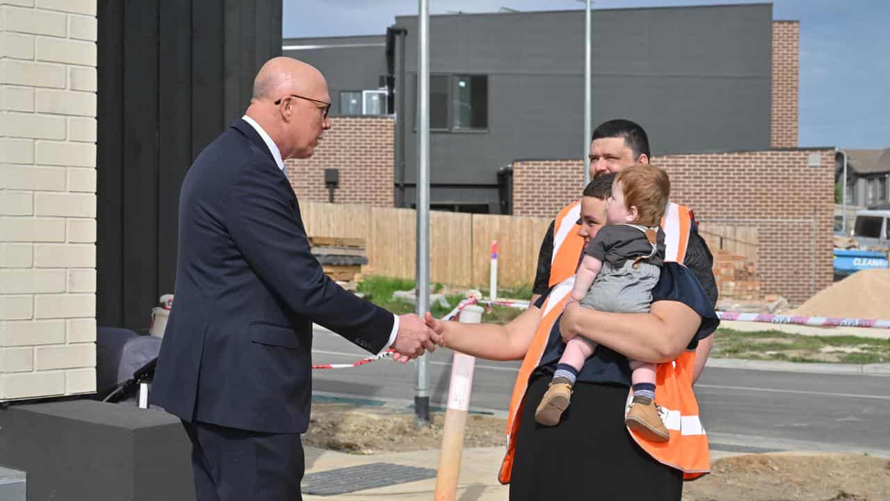 Peter Dutton with a family at a new housing development