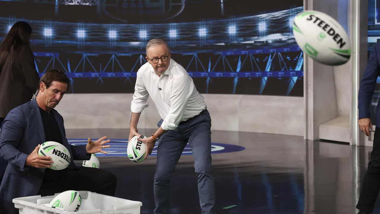 Anthony Albanese passes a football
