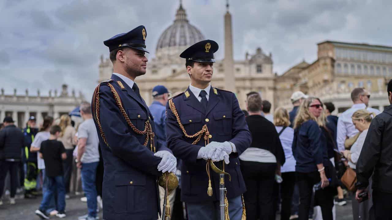 Police in St Peter's Square as people queue for St Peter's Basilica