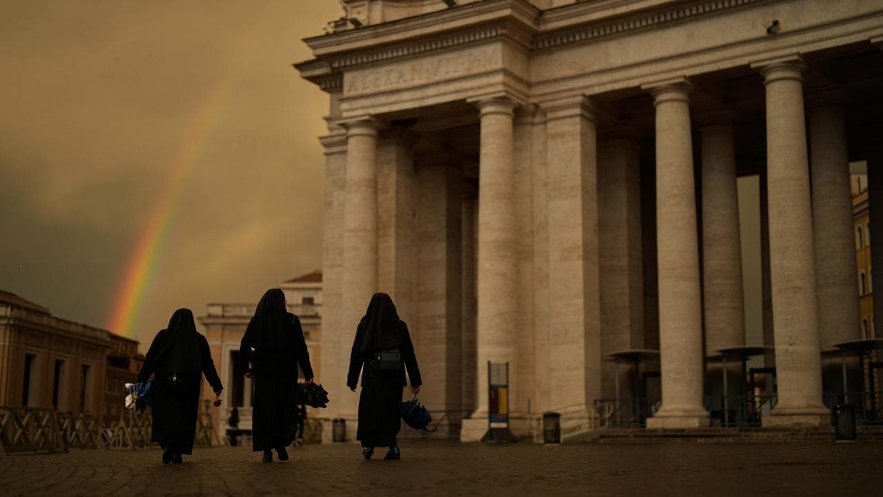 Nuns walk along St Peter's Square