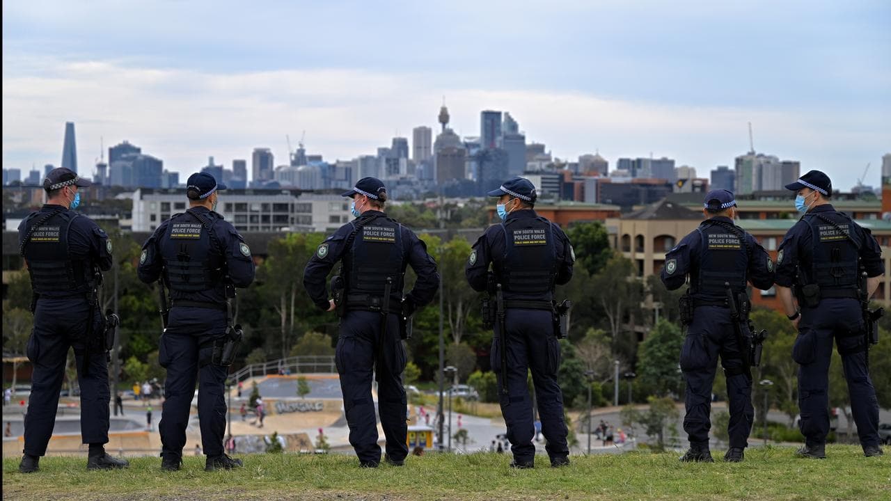 Police officers patrol a park for a protest during the COVID pandemic