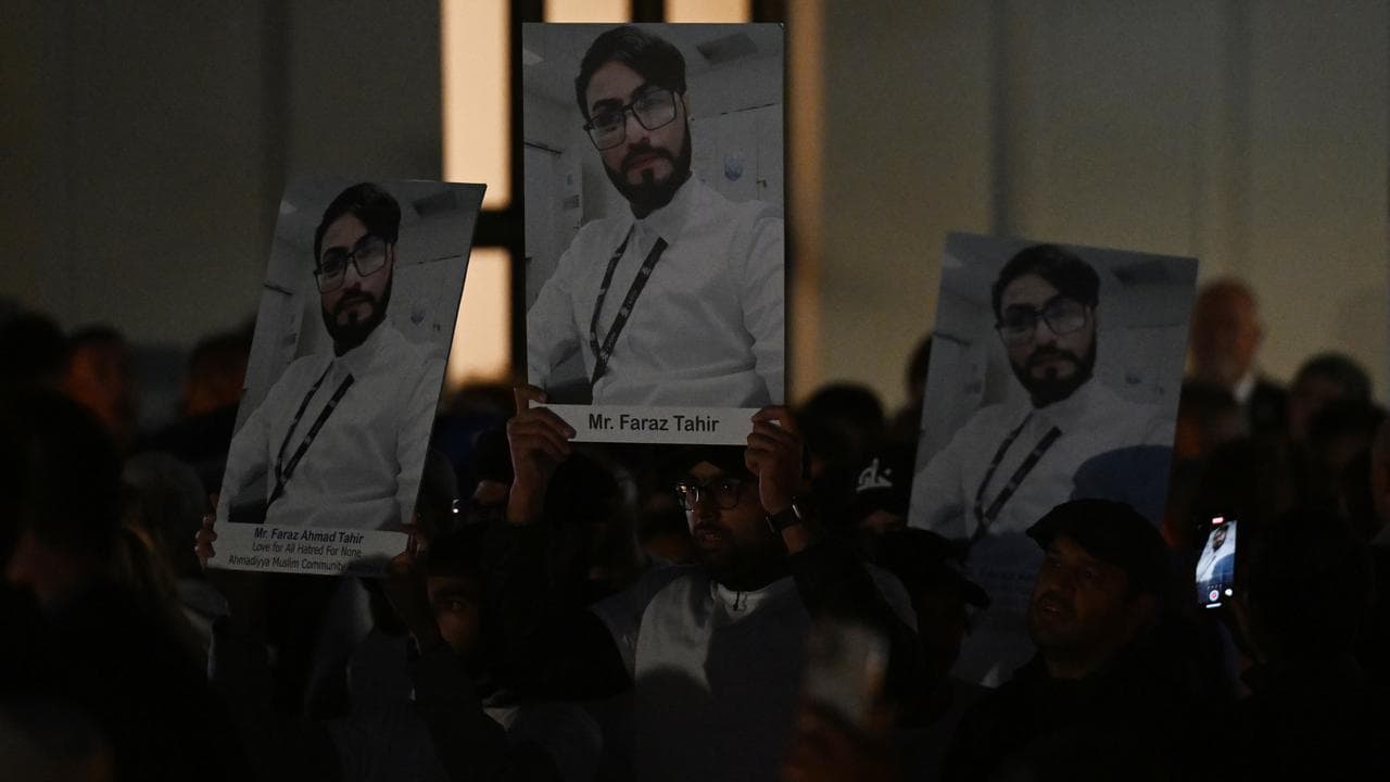 Mourners hold up posters of security guard Faraz Tahir (file)
