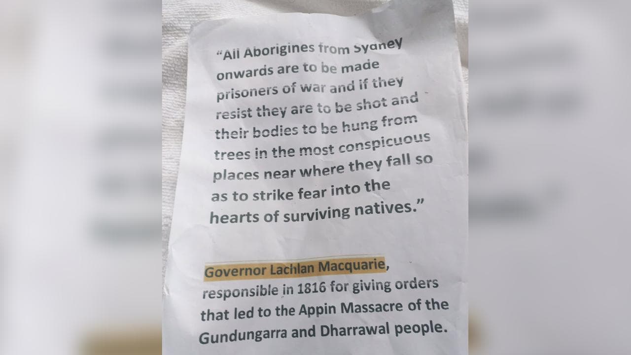 The sign Stephen Langford stuck on a statue of Lachlan Macquarie