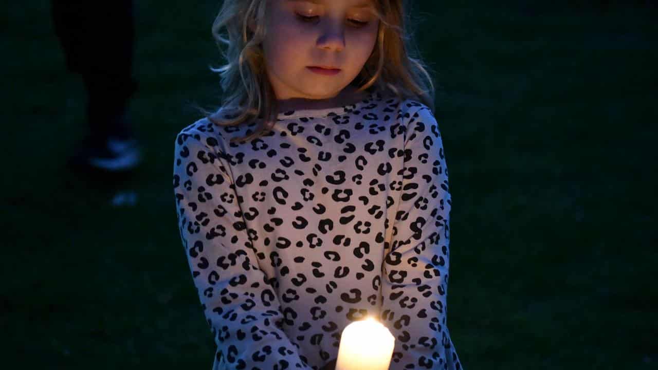 Mourners pay respects to two young boys at a vigil in Coonabarabran