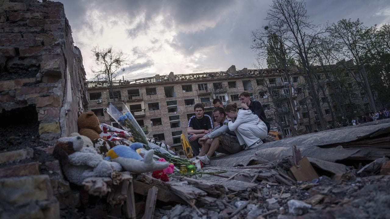 People mourn a friend who died in a Russian strike in Kyiv, Ukraine