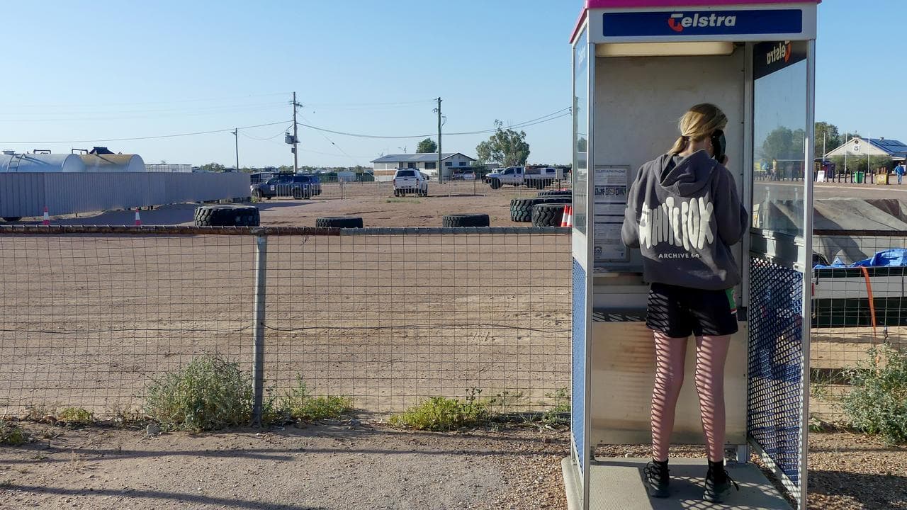A woman uses a phone box in Birdsville