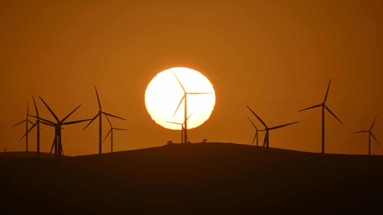 The sun rises over power-generating wind turbines (file image)