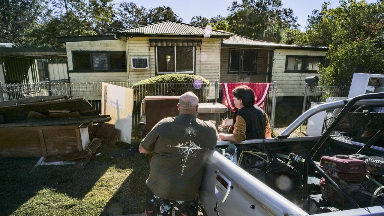 Local residents are seen cleaning up after floods in Taree,