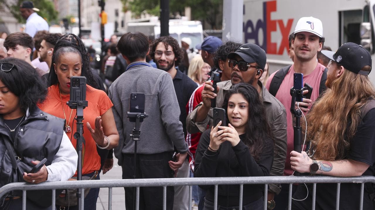 Onlookers live-streaming outside the court