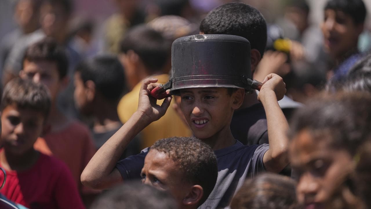 A young Palestinian waits to collect food