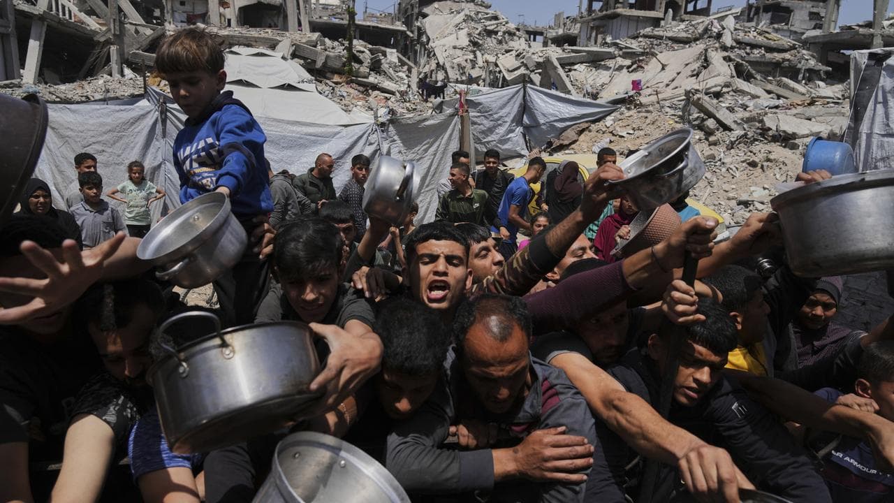 Palestinians struggle to get donated food in Beit Lahia, Gaza Strip