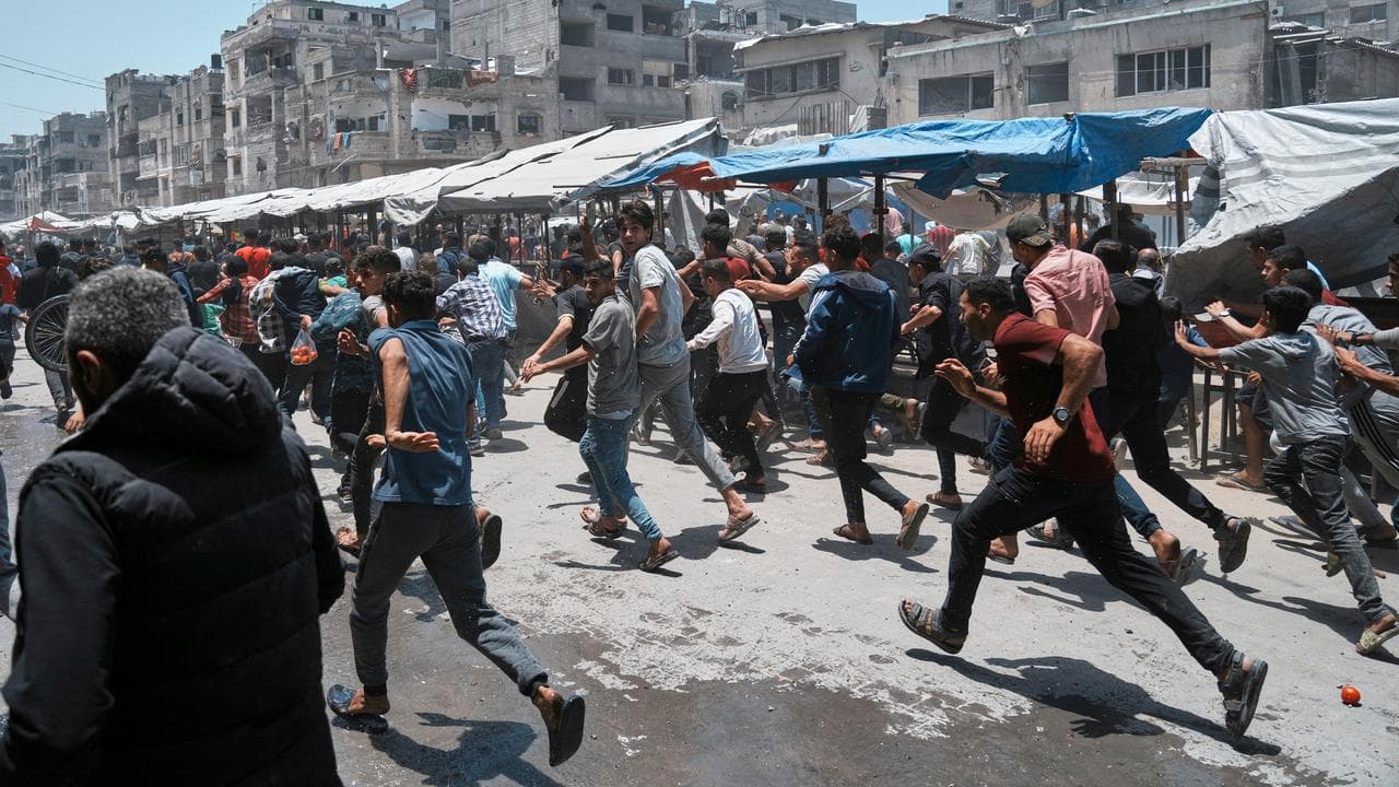 Palestinians run following an Israeli strike in Gaza City