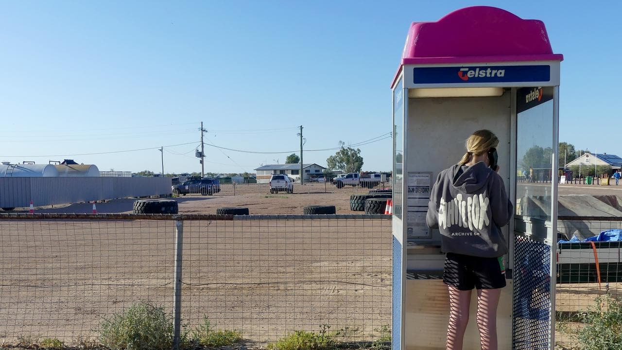 Woman uses a phone box in a rural town