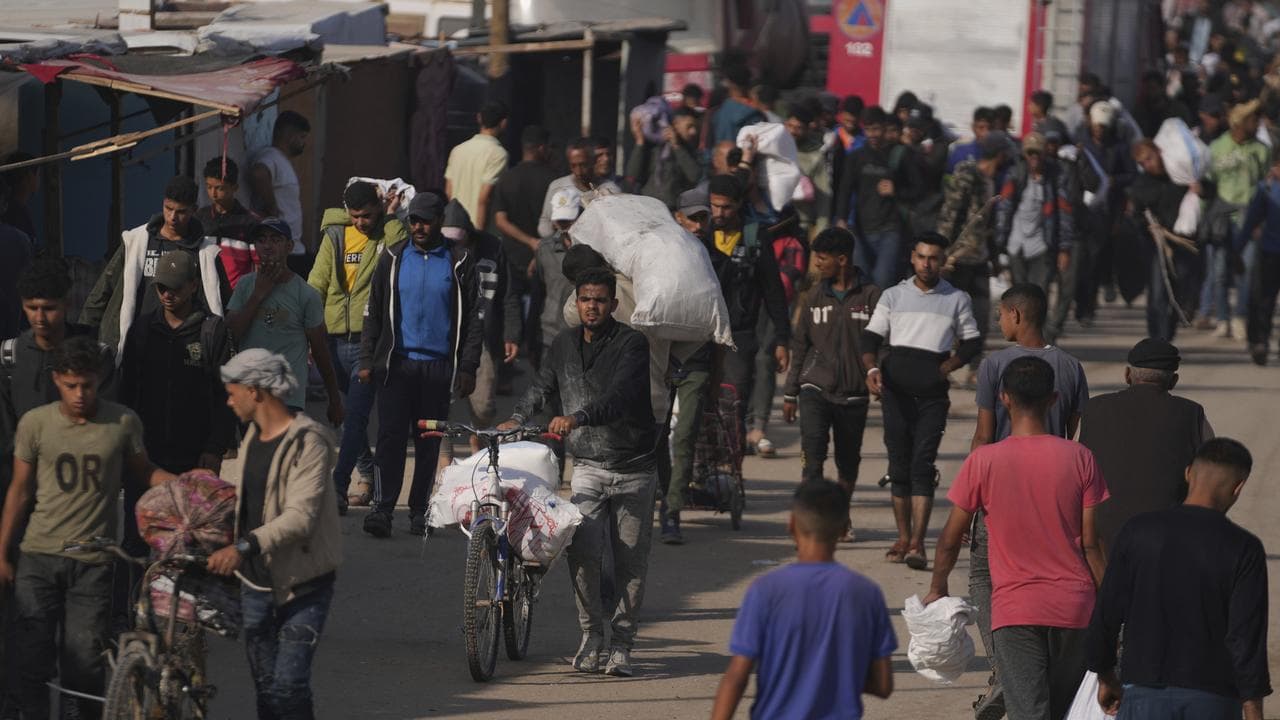 Palestinians carry bags containing food