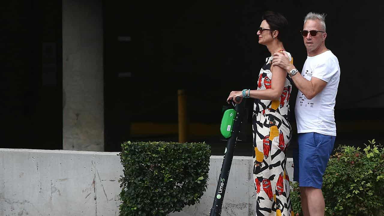 A woman and man riding a Lime-S Scooter in Brisbane