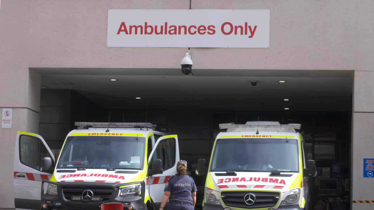 Paramedics at ambulances outside a hospital