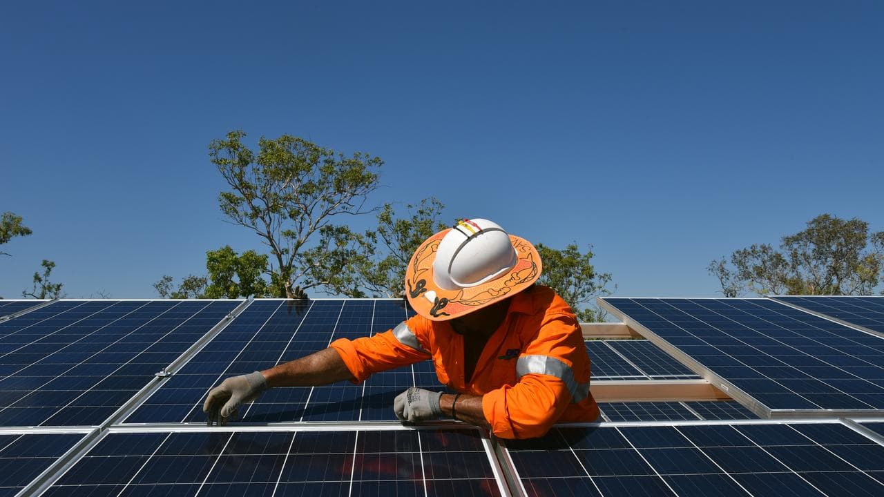 Worker installs solar panels on a roof