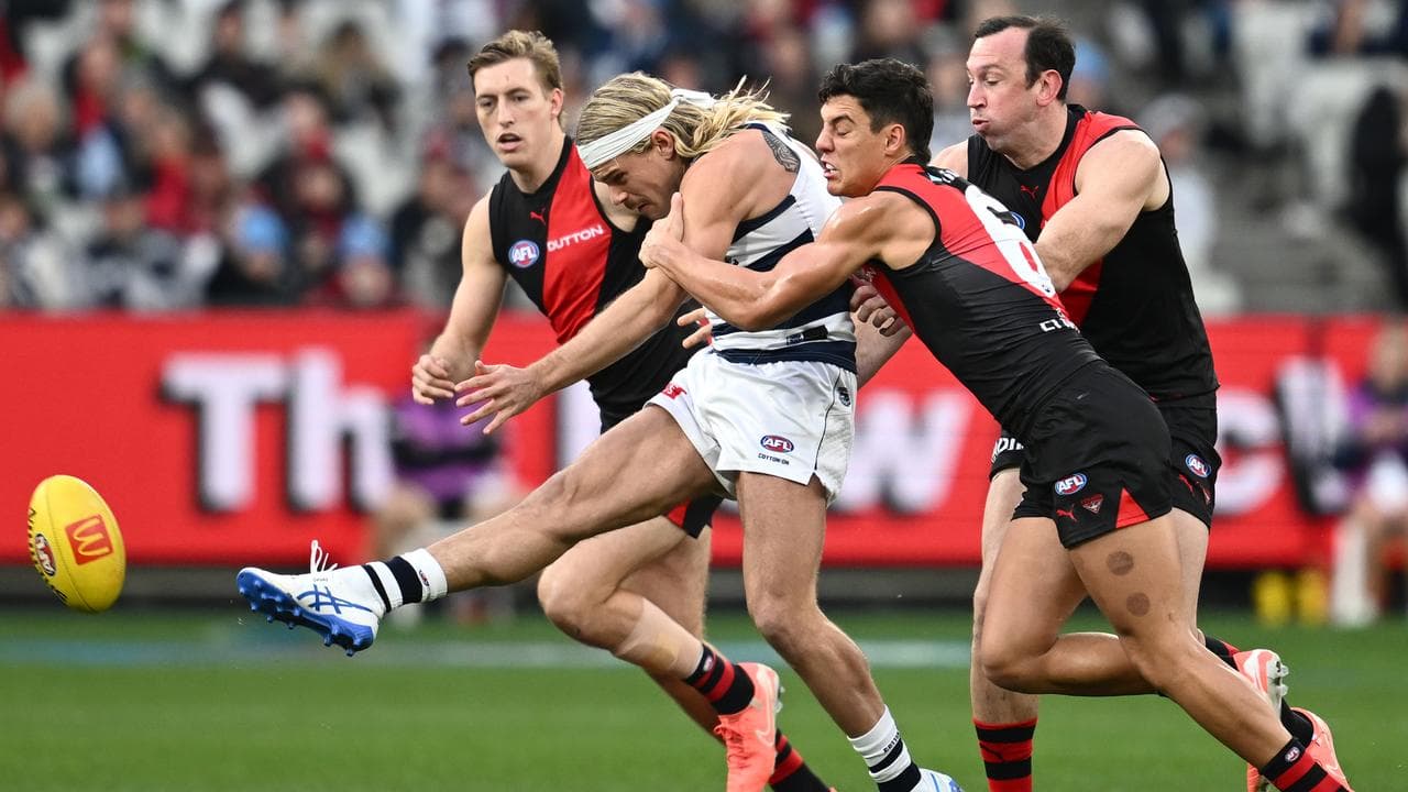 Geelong's Bailey Smith manages to get a kick away