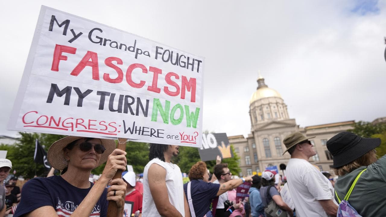 A demonstrator holds a sign during a "No Kings" protest  in Atlanta. 