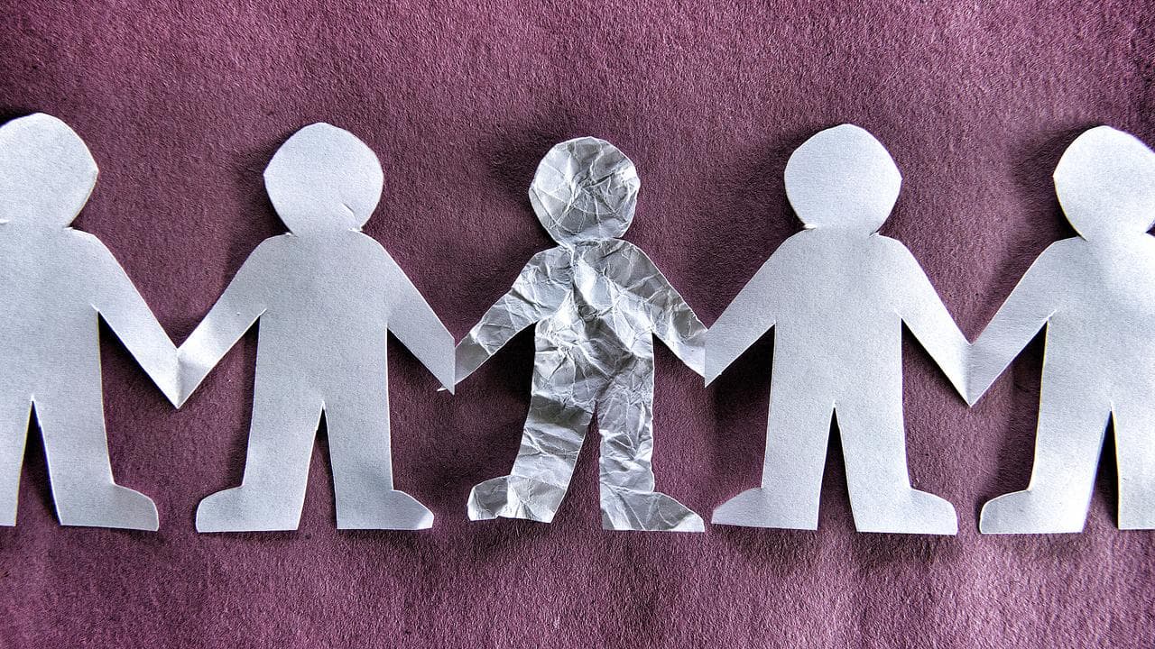 Paper cut out of people holding hands