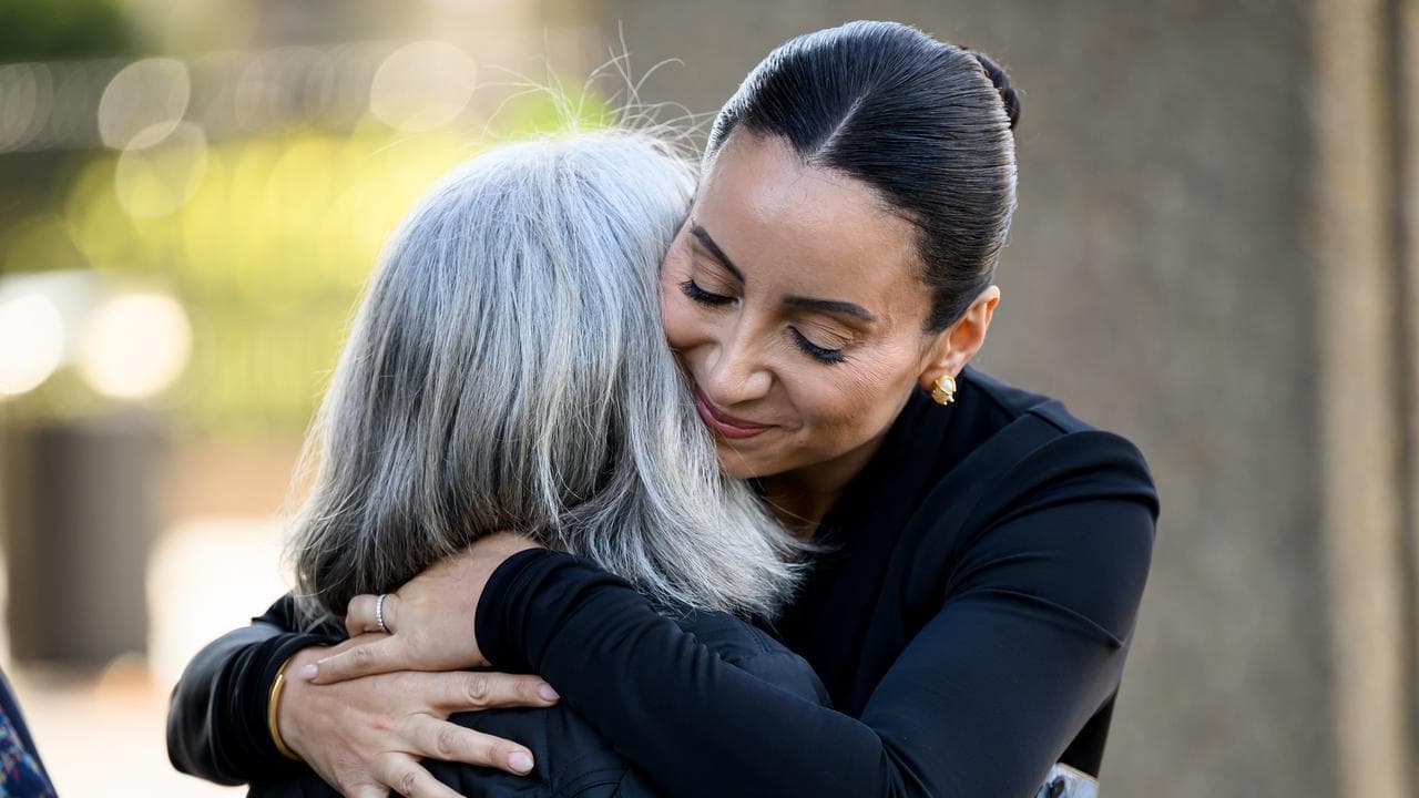Antoinette Lattouf (right) embraces a supporter outside court