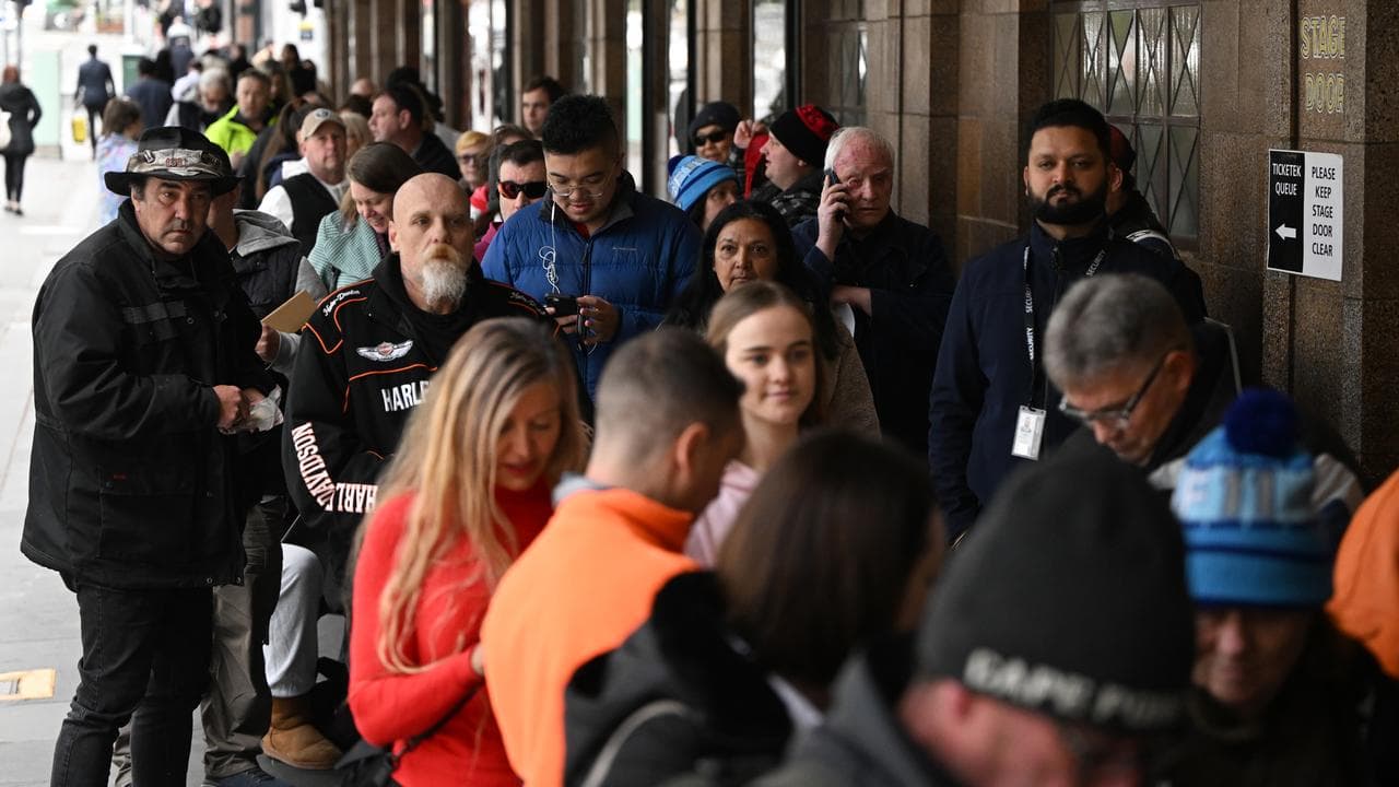 People wait to purchase tickets