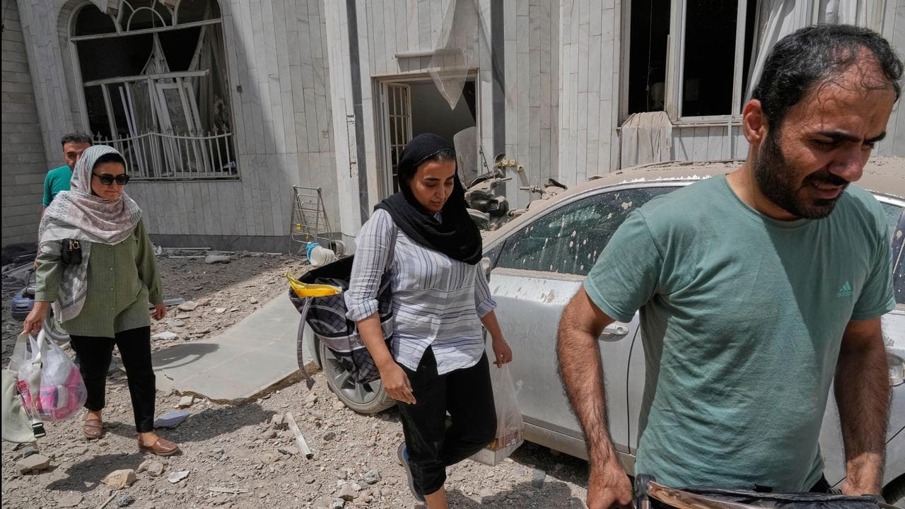 People leave their home after an Israeli air strike in Tehran, Iran