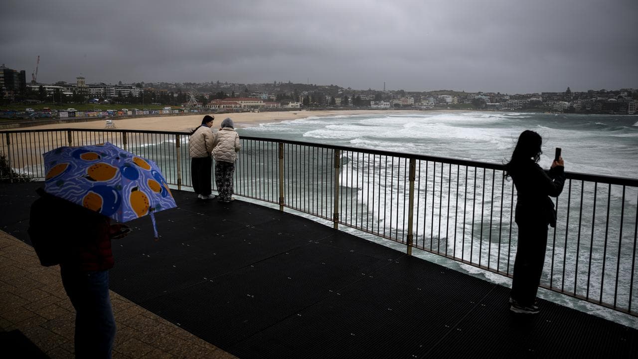 People watch the large swells at Bondi Beach in Sydney