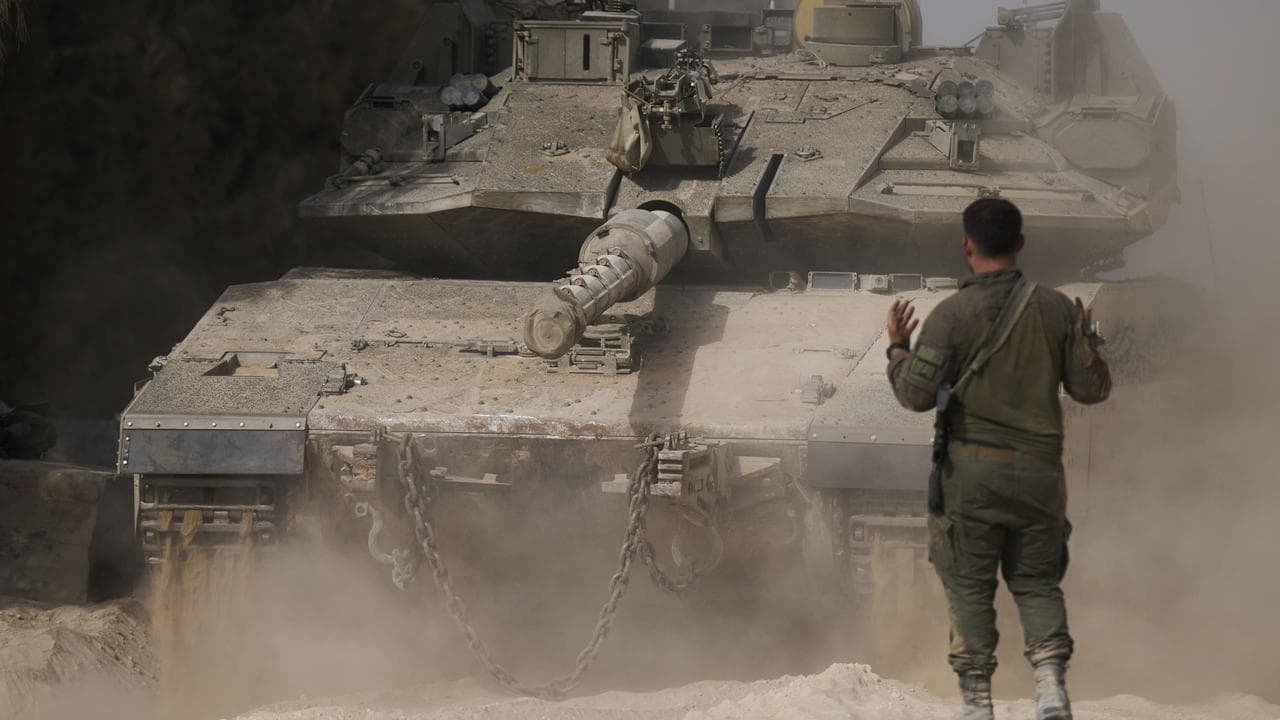 Israeli soldier directs a tank near the Gaza Strip