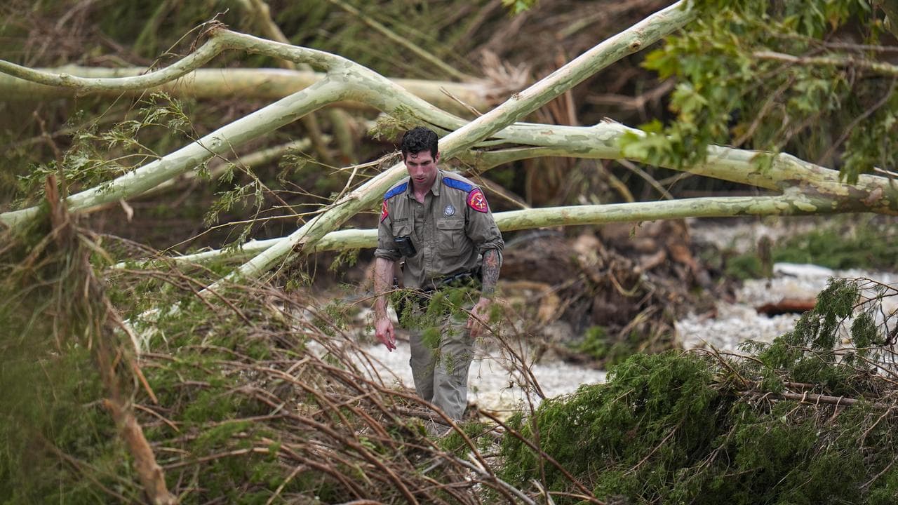 A rescue worker combs through the banks of the Guadalupe River