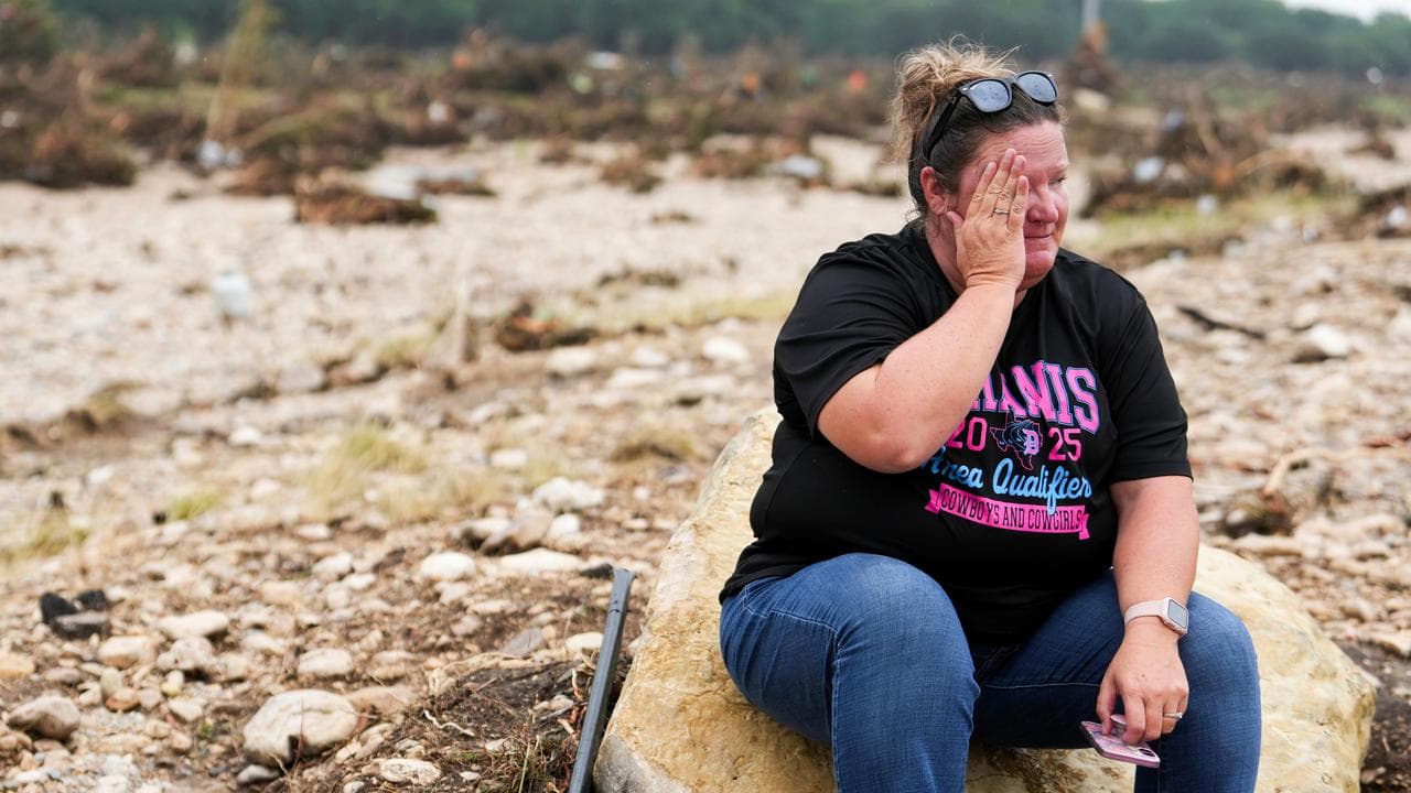 Woman rests in search for flood survivors in Texas