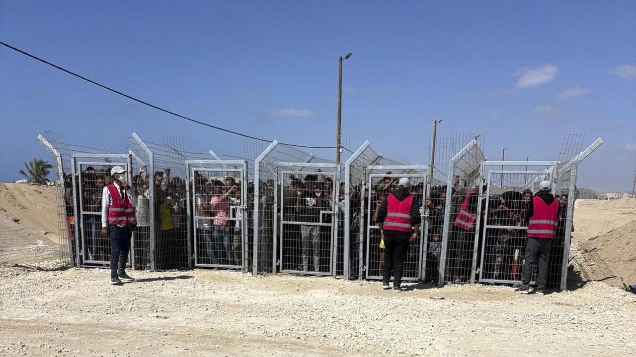 Palestinians behind gates before entering a food site