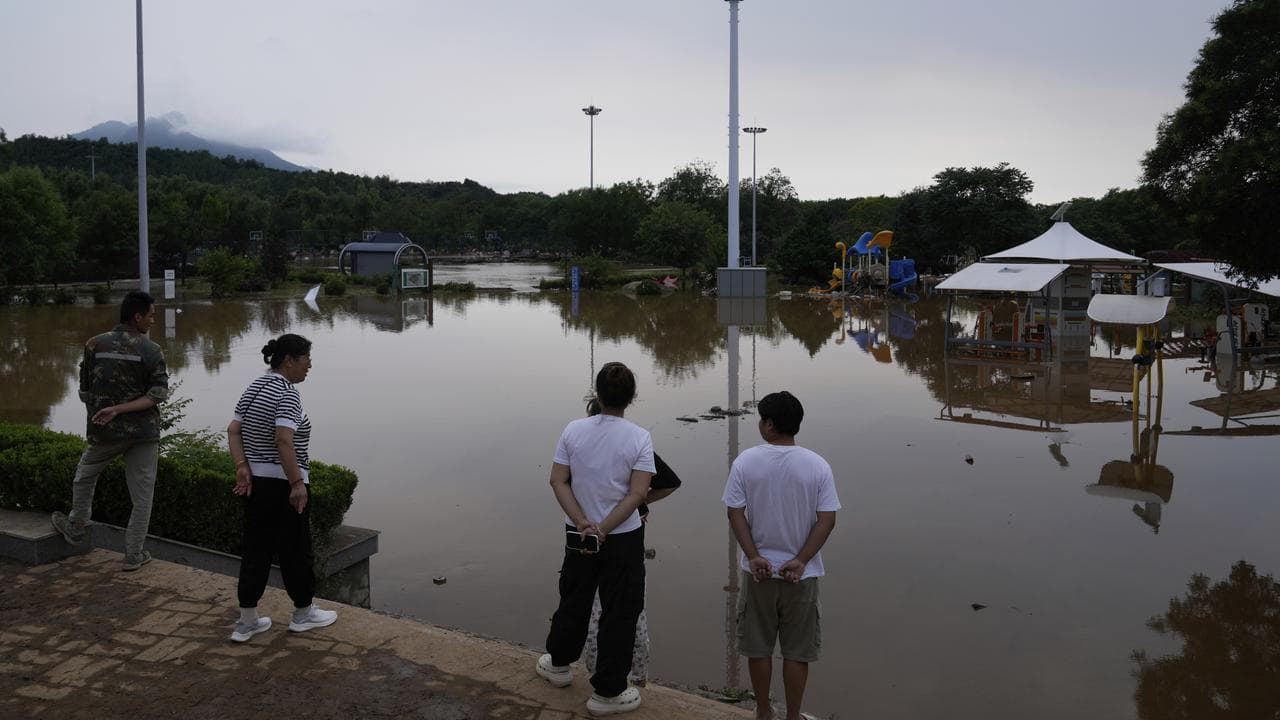 People at a flooded park after heavy rains in Miyun district, China