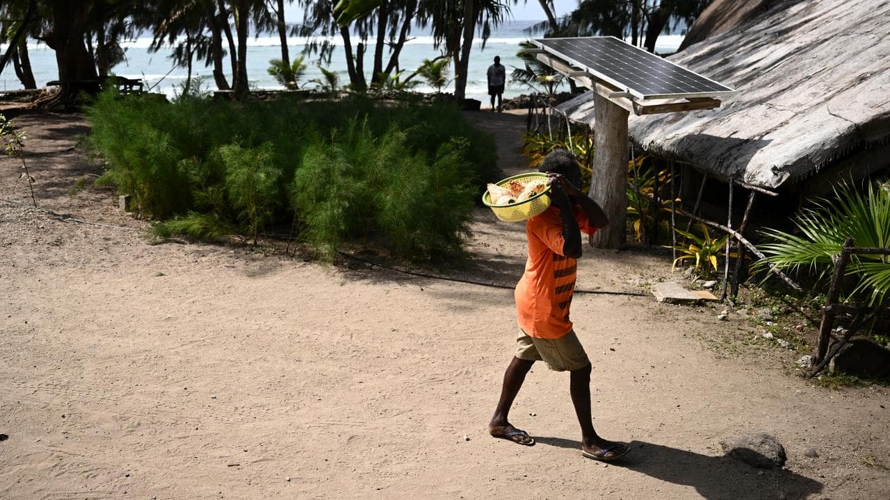 A man passes a solar panel