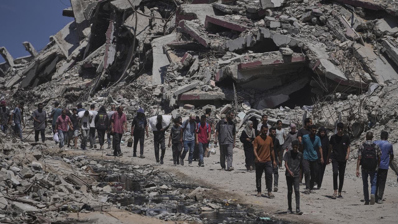 Palestinians carry sacks of humanitarian aid in Gaza