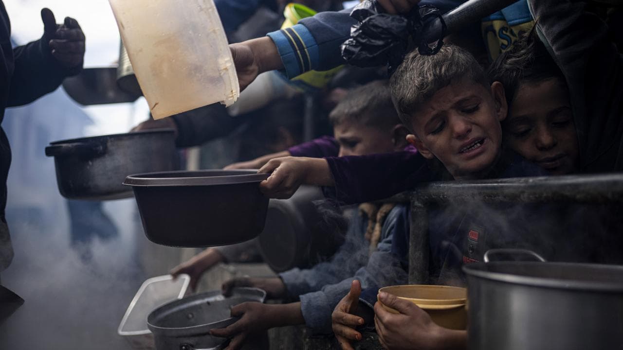 Palestinians line up for a meal in Rafah, Gaza