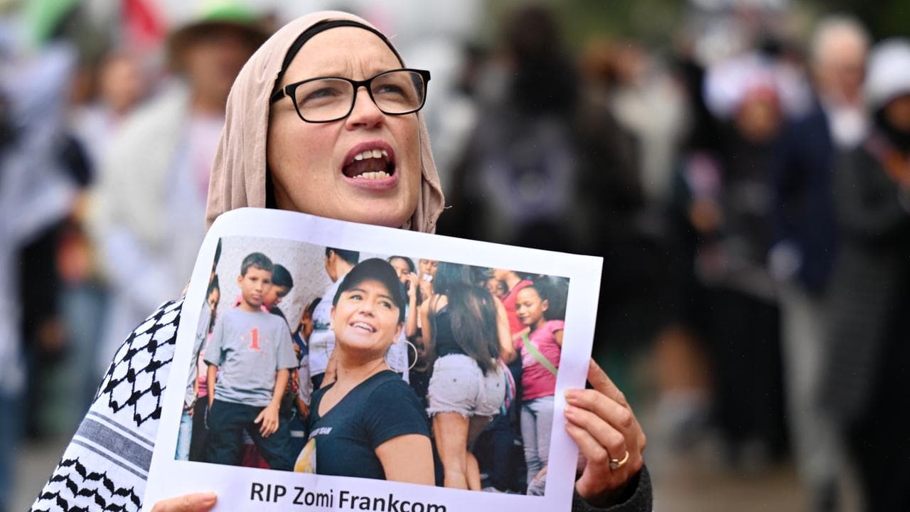 A person holds a placard of Australian aid worker Zomi Frankcom
