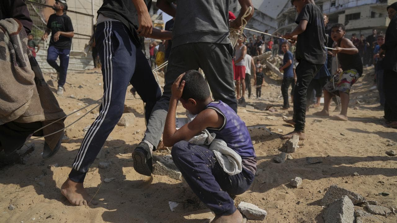 People rush to collect aid airdropped by parachutes into Gaza City