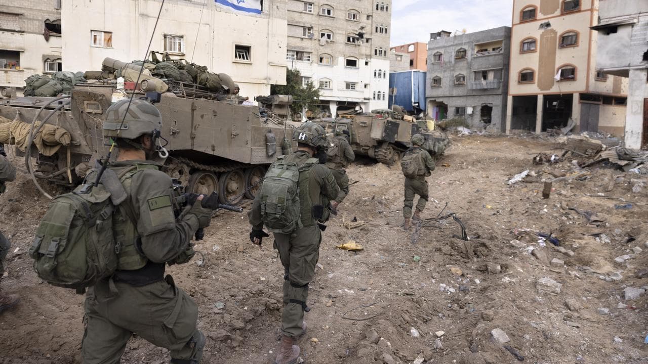 Israeli soldiers walk in Gaza City's Shijaiyah neighborhood