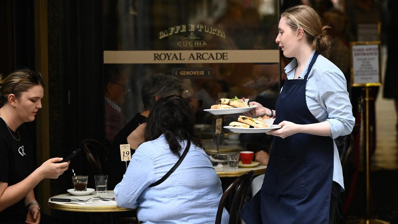 A cafe worker serves coffee in Melbourne