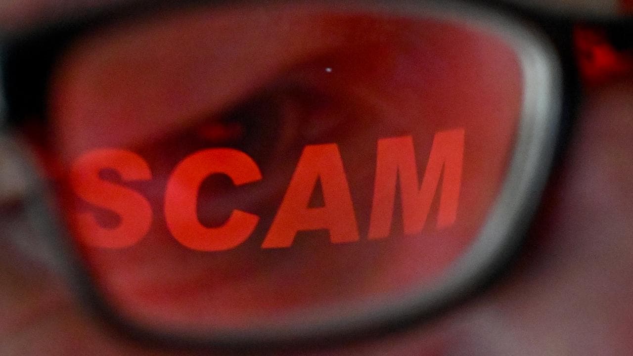 The word ‘scam’ reflected in a person’s glasses (file image)