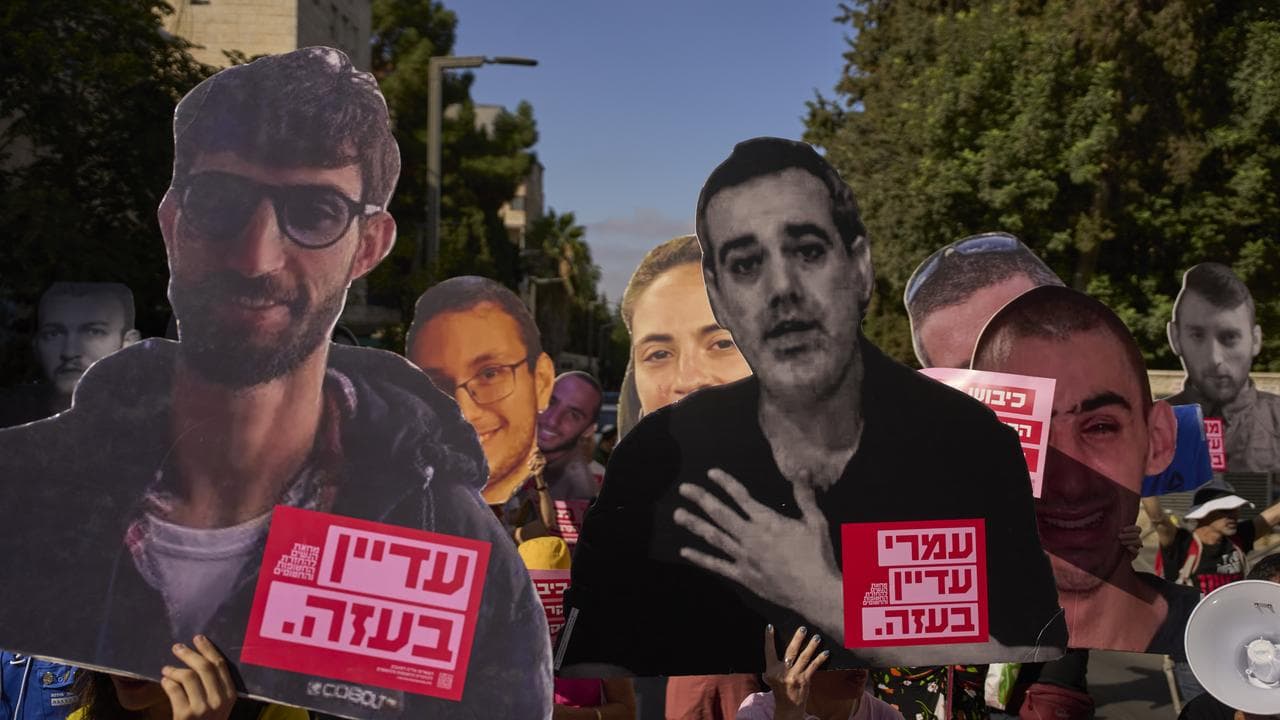 Families and supporters of Israeli hostages hold photos