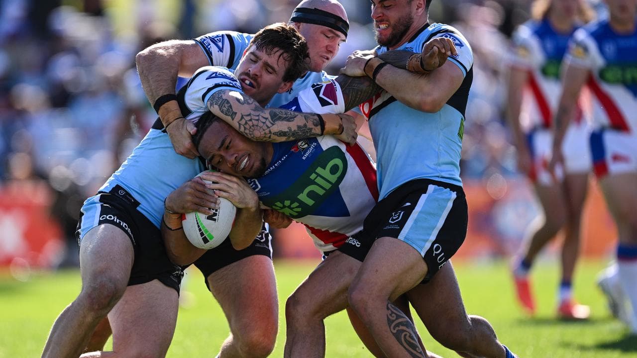 Newcastle's Greg Marzhew tries to navigate through a school of Sharks.