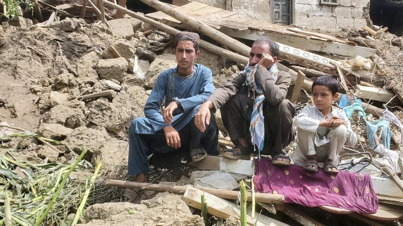 Survivors sit on the rubble